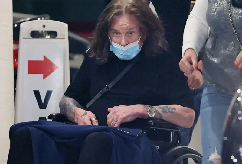 Ozzy Osbourne recebe auxílio de cuidadores em cadeira de rodas